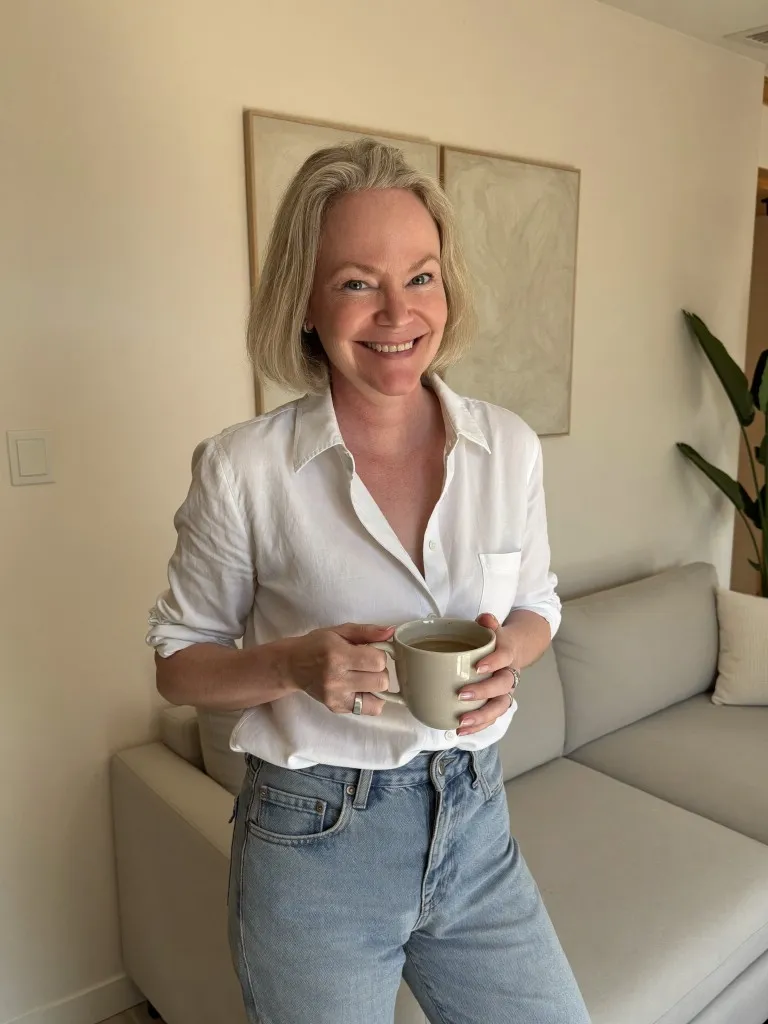 AI personal brand portrait with natural grey-blonde hair in a bright living space